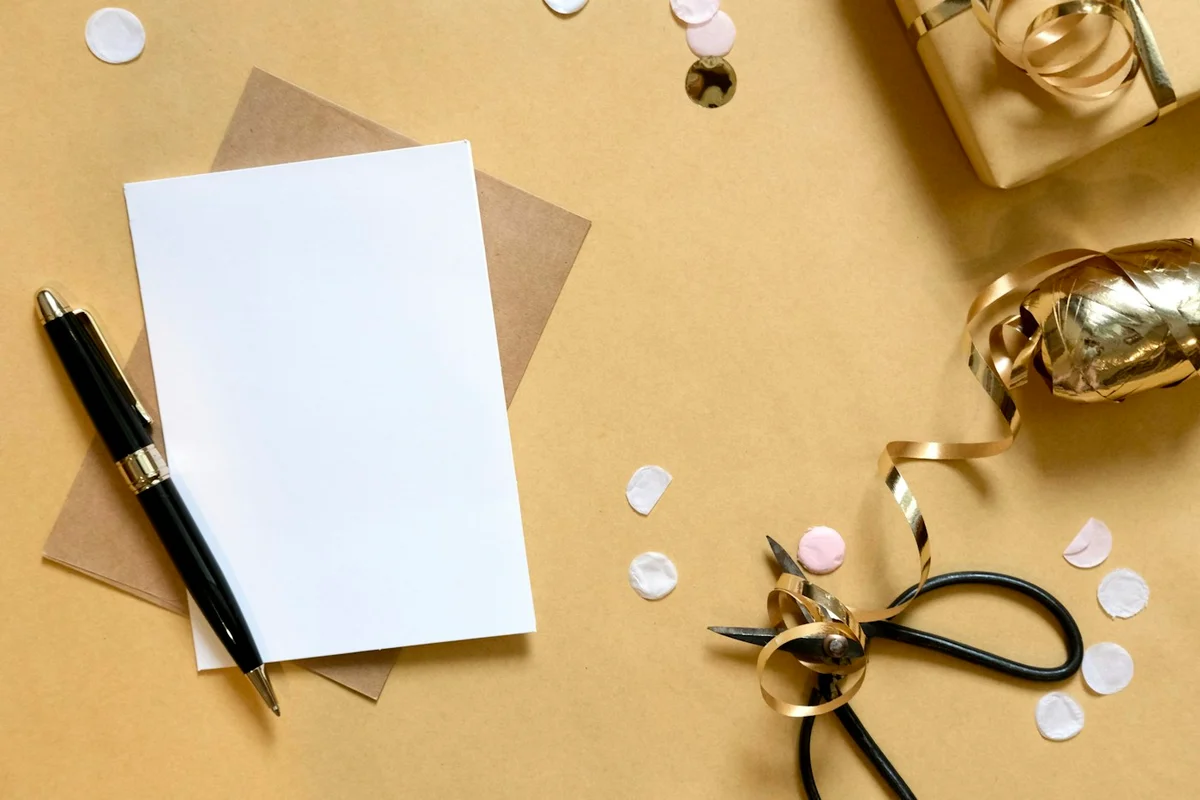 Gift box, ribbon, card and pen arranged on a desk